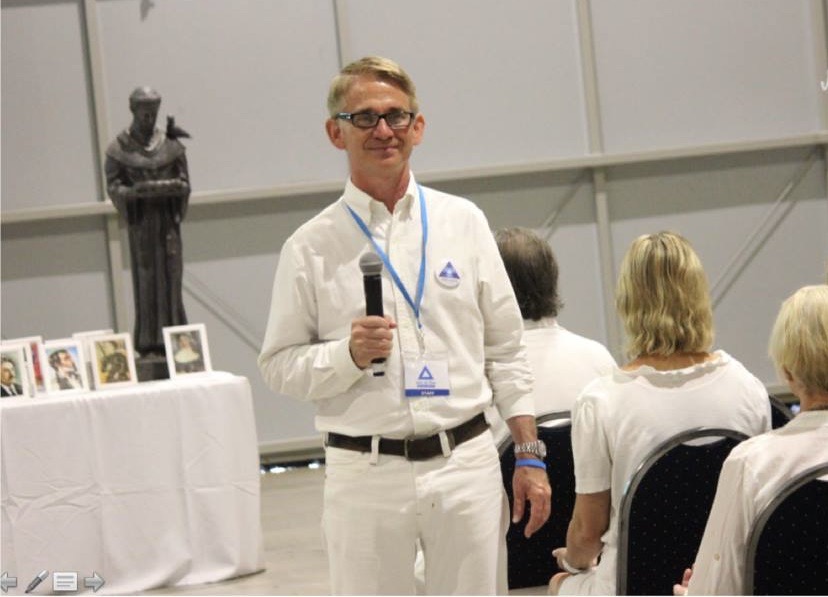 Paul McCarthy leading meditation at a meditation event in the spiritist tradition for several thousand people. 